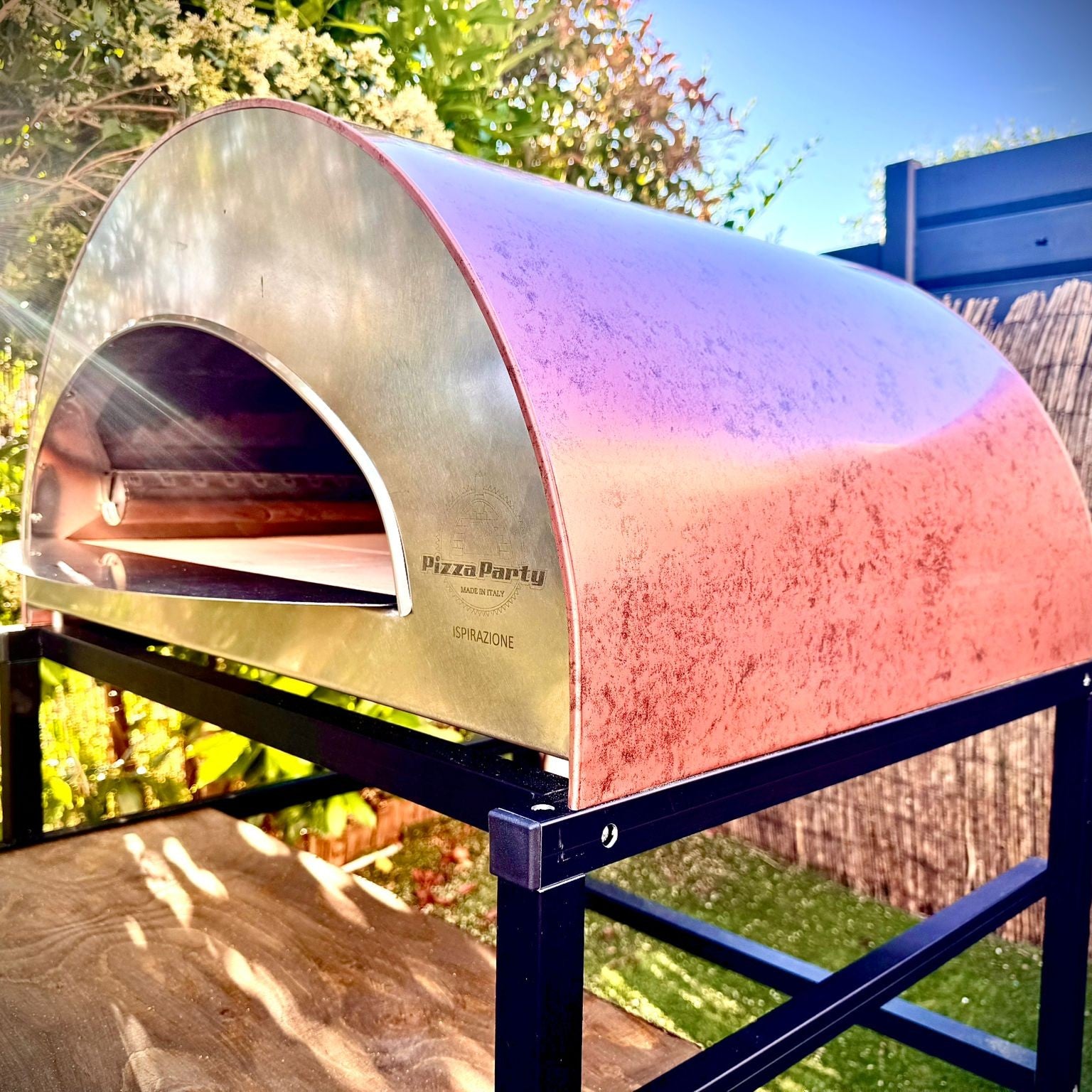 Interno del forno Pizza Party Ispirazione Grande con bruciatore acceso al rosso e piano cottura in biscotto, logo Pizza Party Made in Italy visibile