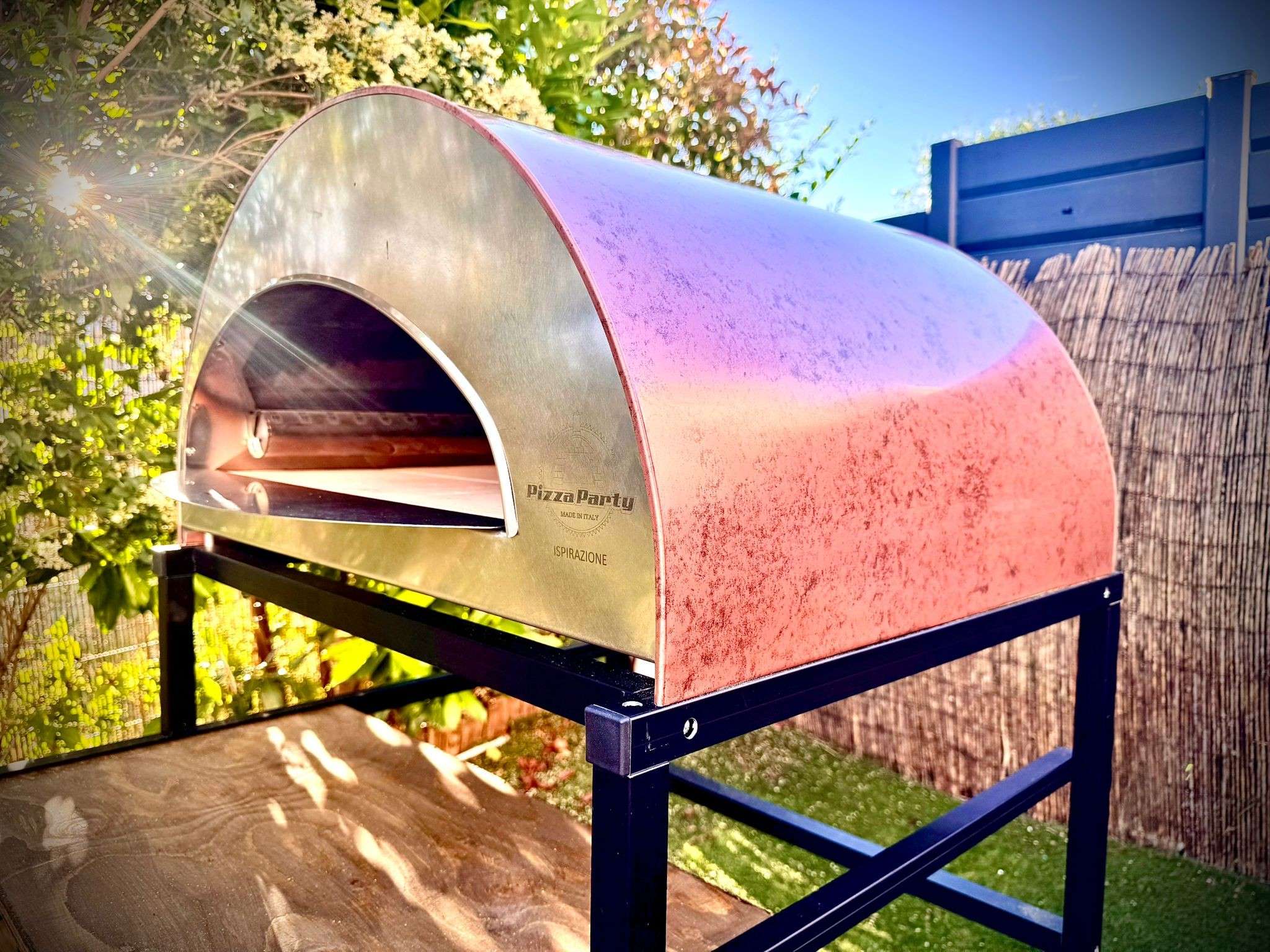 Interior of the Pizza Party Grand Inspirations oven with a red-glowing burner and pizza stone cooking surface, featuring the visible Pizza Party Made in Italy logo