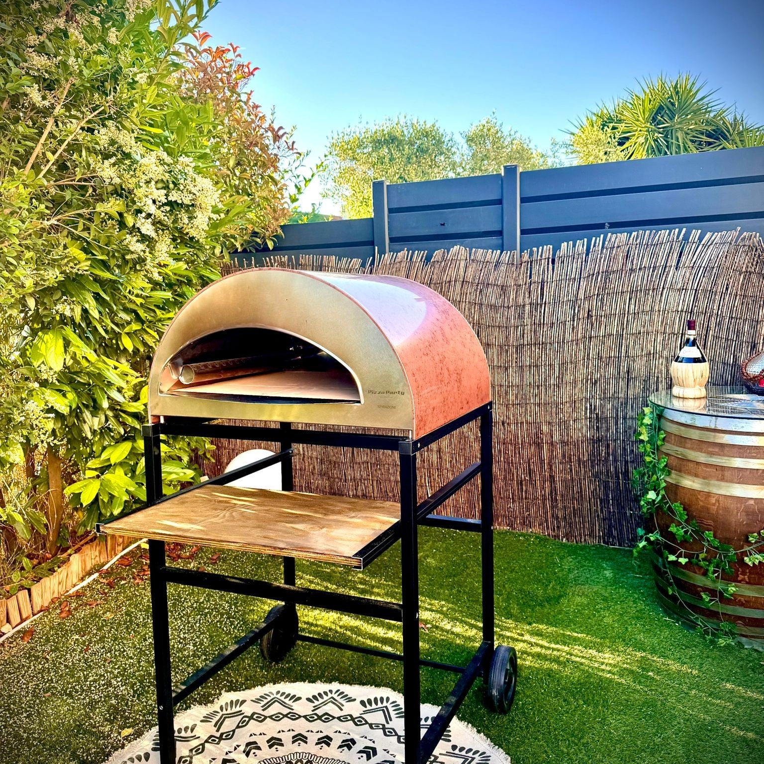 Forno Pizza Party Ispirazione Grande rame antico su carrello con ripiano in legno, in giardino con prato verde