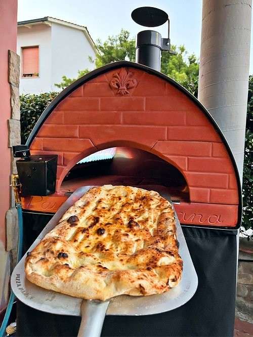  Pizza gebakken met de schep van de Pizza Party Passione hybride gas buitenoven