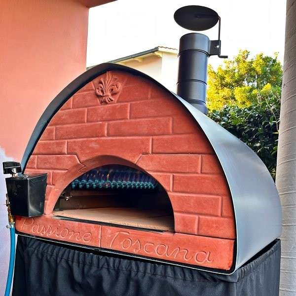 Forno Pizza Party Passione op gas met brandvlam en zwarte hoes in de tuin