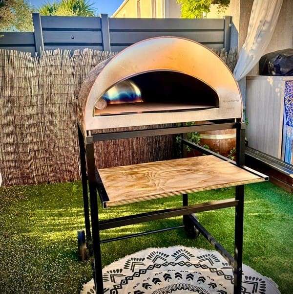 Black wheeled Pizza Party cart with Emozione oven and wooden terrace shelf