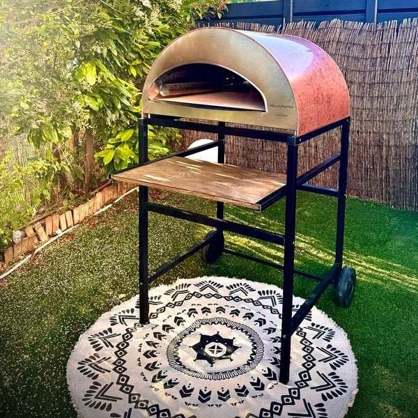 Black wheeled Pizza Party stand with Emozione oven for garden and sliding wooden shelf