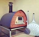 Horno de leña Pizza Party 70x70 'Piedra' con soporte de acero y palas Vesuvius apoyadas, vista lateral