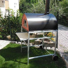 Four à bois Pizza Party Pizzone noir sur support avec roues en aluminium dans le jardin